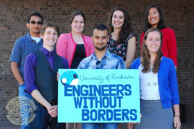 A group of students at the University of Rochester hold a sign that reads “Engineers Without Borders”