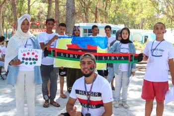 A group of young Libyans at a summer camp, holding the Libyan flag