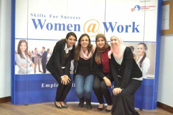 طالبات أمام لافتة كتب عليها "مهارات النجاح: النساء في العمل"
